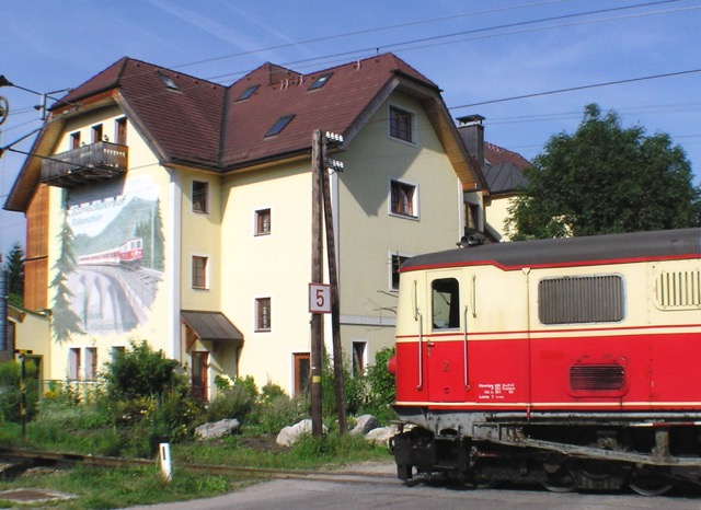 Schmalspurjuwelen: Mariazellerbahn vorm Steinschalerhof mit historischer Lok und Wandgemälde